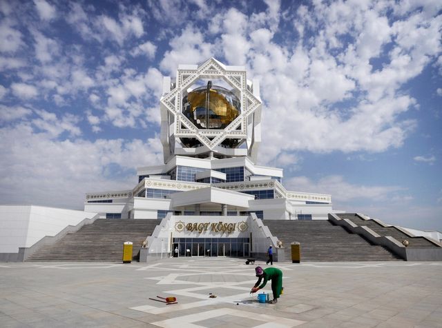 Прибирання площі перед "Палацом щастя" в Ашхабаді. Усередині палацу є кімната, де молодята постають перед портретом президента Туркменістану- фото 177474