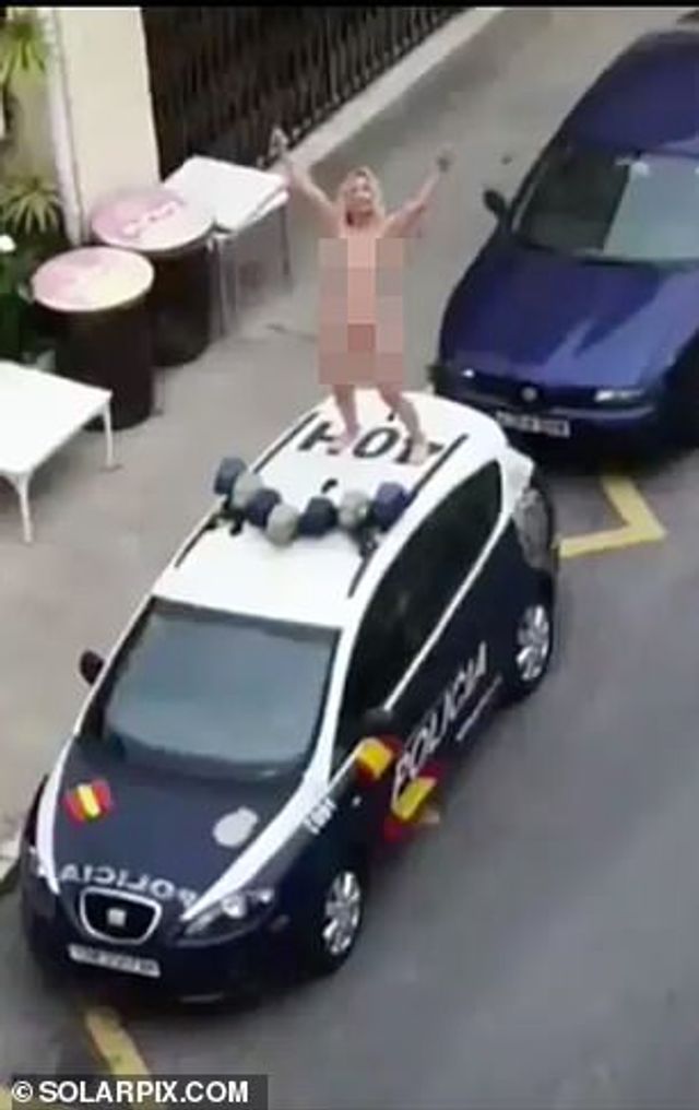 Смілива іспанка повність оголилася і залізла на поліцейське авто: фотофакт - фото 397832