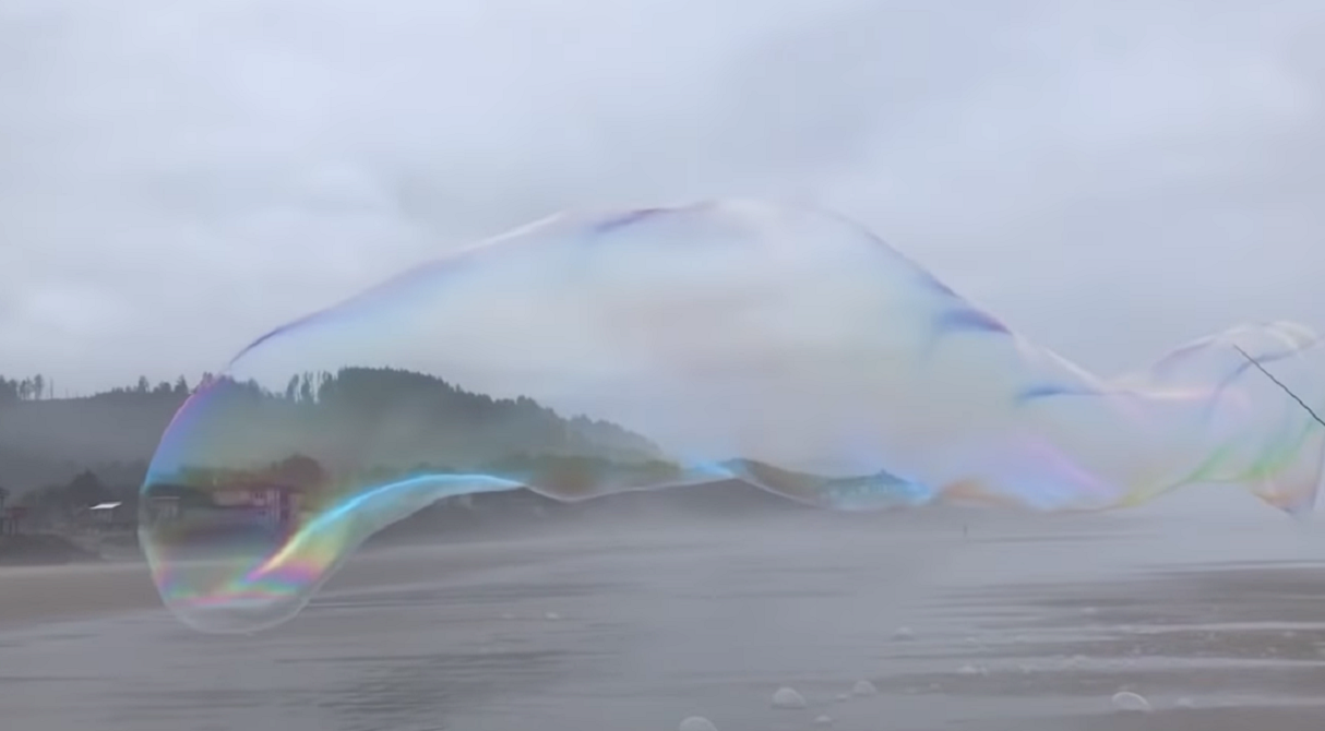 На пляжі в Орегоні надули гігантську мильну бульбашку довжиною у пару десятків метрів