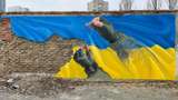 Військовий зшиває прапор України: у Києві з'явився потужний мурал